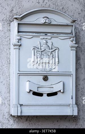 Decorative White Metal Mailbox Mounted on Exterior Residential Wall Stock Photo