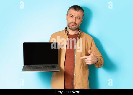 Man Holding Laptop With Blank Screen, Pointing At Device, Business Concept Stock Photo