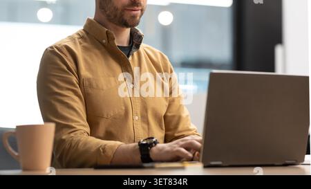 Man Typing On Laptop In Office, Focused, Business Concept Stock Photo