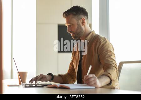 Focused Caucasian Man Typing On Laptop At Office, Business Concept Stock Photo