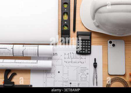 Architectural design and construction planning with blueprint, laptop, and engineering tools on wooden desk Stock Photo
