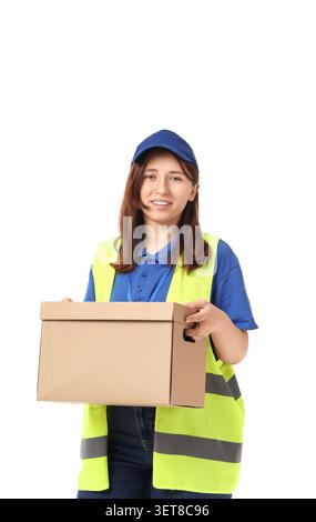 Young female delivery worker in blue uniform and safety vest holding cardboard box, isolated on white background, she is smiling and looking directly Stock Photo