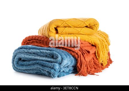 Stacked colorful cozy knitted blankets and soft throws for home comfort and interior decor isolated on white background, the yellow blanket features a Stock Photo