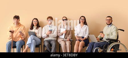 Diverse group of job applicants with disabilities and varied backgrounds awaiting interviews, inclusive employment opportunity Stock Photo