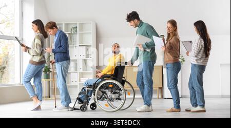 Diverse group of people waiting in line, including man in wheelchair, for job interview or application process Stock Photo