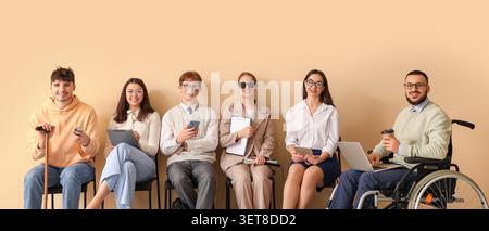 Diverse group of job seekers with disabilities and different backgrounds waiting for interview, inclusive employment opportunity Stock Photo