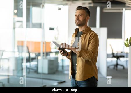 Young Caucasian Man Using Tablet And Working In Modern Office, Business Concept Stock Photo