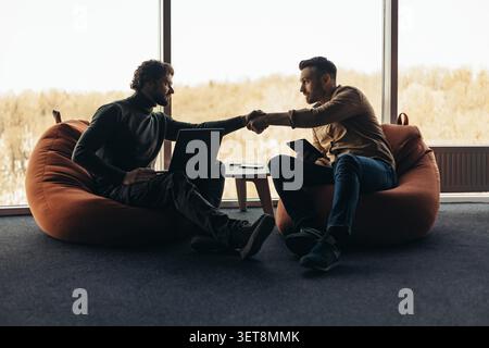 Two Men Shaking Hands In Office Space, Business Discussion Concept Stock Photo