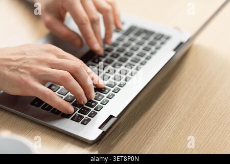 Unrecognizable Hands Typing On Laptop Keyboard In Office Setting, Remote Work Concept Stock Photo