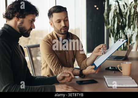Two Men Discussing Business Plans In Modern Office, Collaboration Concept Stock Photo