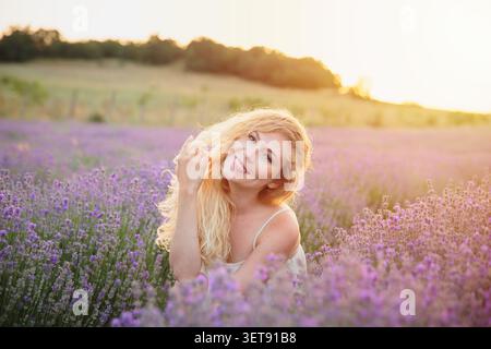 Joyful smiling woman in lavender field golden hour lifestyle Stock Photo
