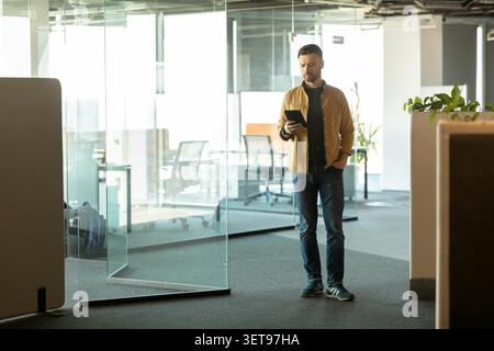 Young Caucasian Man Using Tablet In Modern Office, Business Concept Stock Photo
