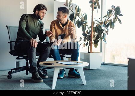 Two Men Discussing Ideas In Modern Office, Business Concept Stock Photo