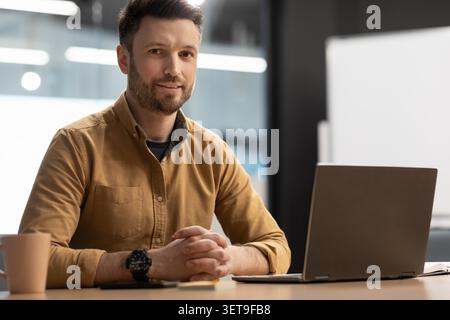 Focused White Male Professional Working At Desk With Laptop In Modern Office Stock Photo