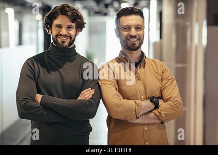 Two Smiling Caucasian Men Standing In Office With Arms Crossed, Business Concept Stock Photo
