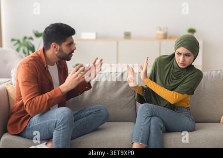Confrontation Between Young Man And Woman With Dismissive Body Language At Home, Conflict Resolution Concept Stock Photo