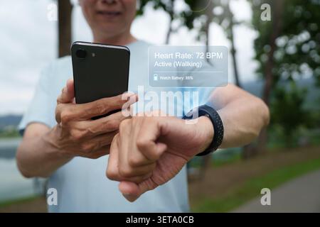 Man using smartwatch with holographic AR interface for health and fitness tracking outdoors Stock Photo