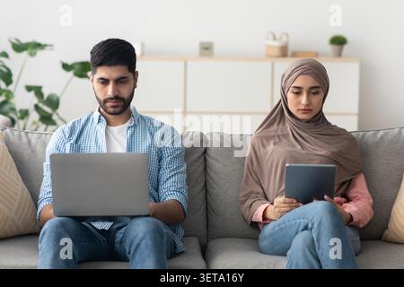 Focused Male And Female Using Laptop And Tablet For Work At Home, Business Concept Stock Photo