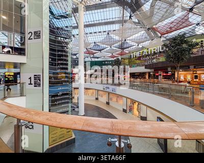 Interior atrium and food court at St. Enoch Shopping Centre in Glasgow, Scotland, featuring modern architecture and glass roof structures. Stock Photo