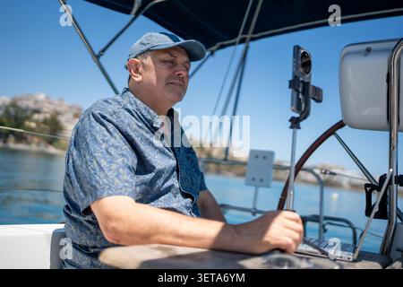 Man vlogging and working on sailboat during summer trip Stock Photo