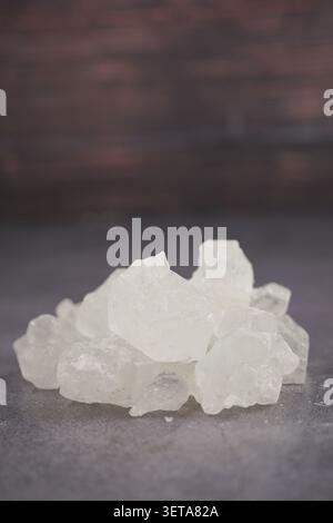 Rock Sugar commonly used as a sweetener in tea are stacked in a small pile on a flat surface Stock Photo