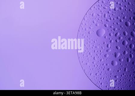 Water droplets on glass slide forming an abstract purple pattern Stock Photo