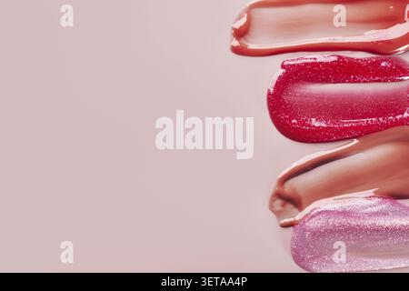 Variety of pink lip gloss patterns on pastel background Stock Photo