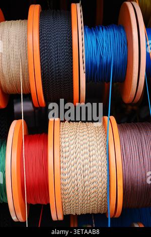 Colorful spools of thread on display at a market stall Stock Photo