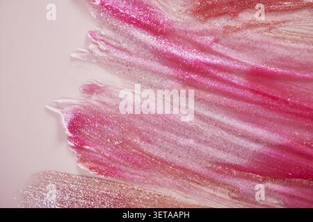 Bright pink and gold glitter brush strokes on a soft pink background Stock Photo