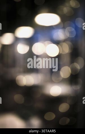Blurry bokeh lights create an abstract and glowing night background texture Stock Photo