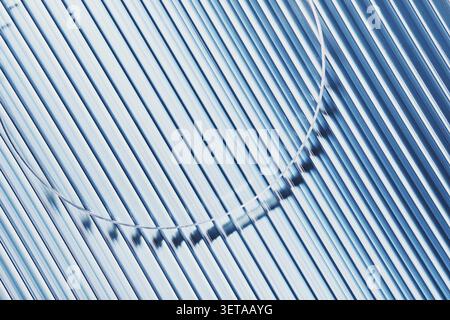 Close-up view of empty Petri dish on blue striped ribbed glass background. Model for a cosmetic product sample Stock Photo