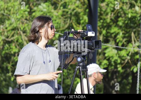 St. Petersburg, June 25, 2022: Professional video cameraman films event with video camera on stand. Live TV broadcast Stock Photo