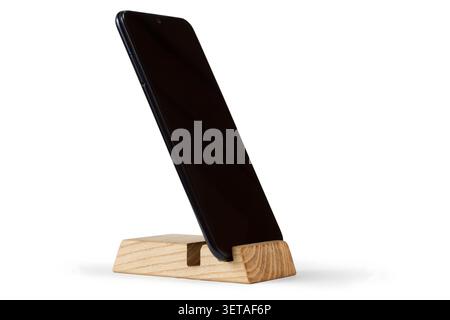 Smartphone stand. A modern phone on a wooden stand. Smartphone on a white background. Stock Photo