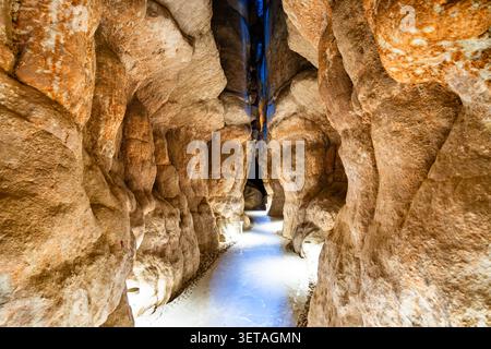 A scenic illuminated stone pathway winding through the narrow caves of Al Qarah Mountain in the Al Ahsa region of Saudi Arabia. Stock Photo