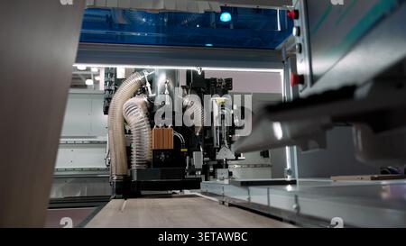 Industrial cnc machine processing wood panel with precision, representing modern factory automation, manufacturing, and technology Stock Photo