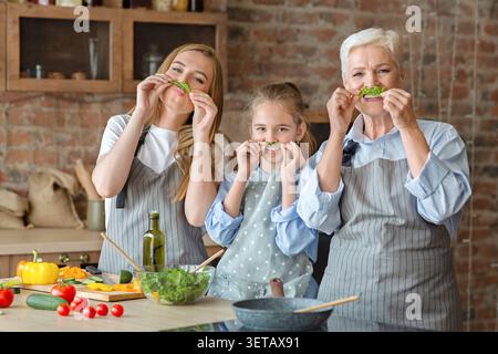 Three Generations of Women Cook Together in a Cozy Kitchen While Having Fun With Fresh Vegetables Stock Photo
