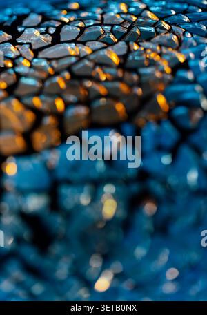 Macro blue cracked glass texture with warm golden light and shallow depth of field for abstract background Stock Photo