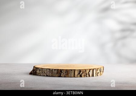 Single rustic wood slice podium on clean white background with soft shadow and large copy space for product mockup Stock Photo