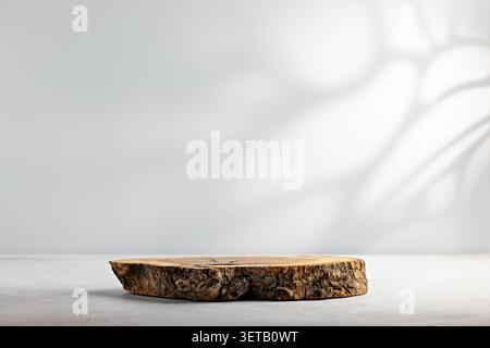 Simple rustic wood slice podium on clean white background with soft shadow and empty copy space for product mockup Stock Photo