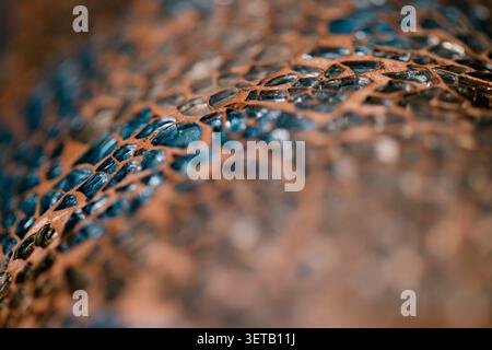 Diagonal copper mesh macro with blue glossy detail and blurred foreground for tactile texture background Stock Photo