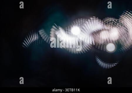 White dotted light trail on dark background with soft bokeh for futuristic abstract design Stock Photo