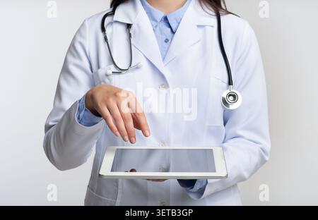 Unrecognizable Doctor Using Tablet Computer, White Background, Cropped Stock Photo