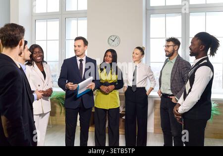 Business team standing in office meeting, sharing ideas and planning strategy Stock Photo