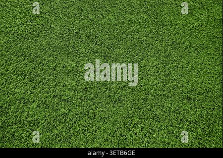 Artificial green grass texture background. Top view of synthetic sports turf lawn. Clean field carpet pattern Stock Photo