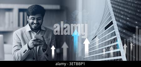 Indian CEO businessman browsing on his smartphone in modern office Stock Photo