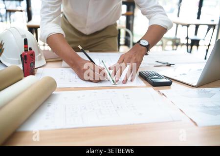 Engineer Drafting Plans at Desk in Construction Office Stock Photo