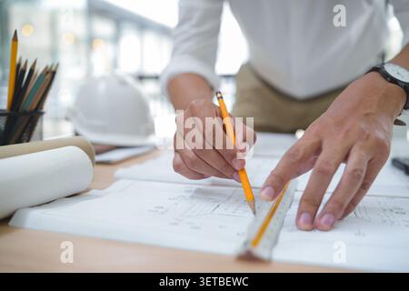 Architect or Engineer Working on Construction Plans in Office En Stock Photo