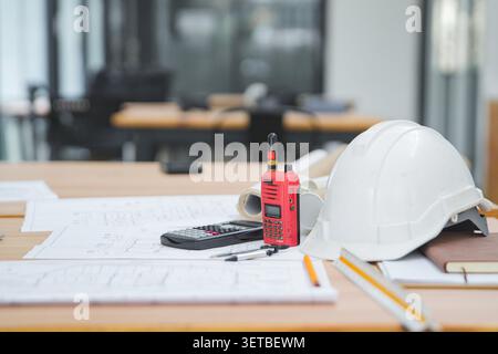 Construction Tools and Equipment on a Desk with Blueprints and a Stock Photo