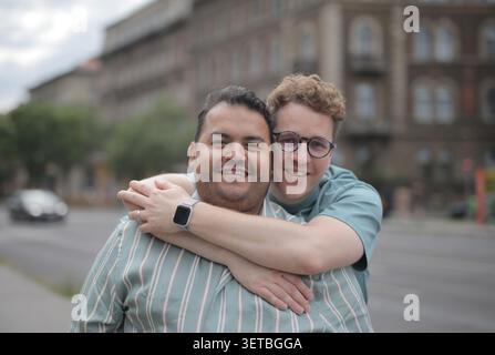 Happy gay couple embracing on a city street Stock Photo