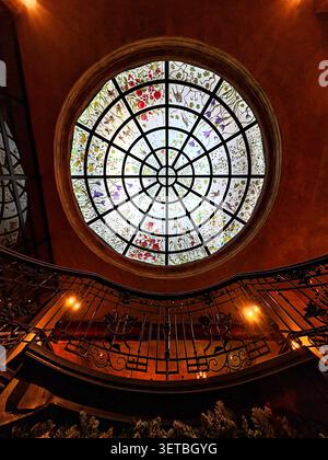 Circular stained glass dome with floral motifs viewed from spiral staircase below at Baku Book Center. Baku, Azerbaijan. Stock Photo